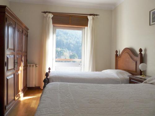 a bedroom with two beds and a window at Horizonte do Gerês in Geres