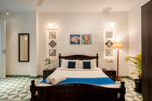 a bedroom with a large bed and a white brick wall at HideAway 2BHK Duplex Villa, North Goa (STU) in Mapusa