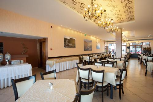 a dining room with tables and chairs and chandeliers at Hotel Lefas in Delphi