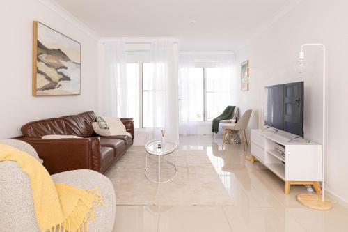 a living room with a couch and a tv at Lake Illawarra Family Escape in Lake Illawarra