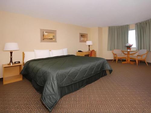 a hotel room with a bed and a table and chairs at Travelodge by Wyndham Absecon Atlantic City in Absecon