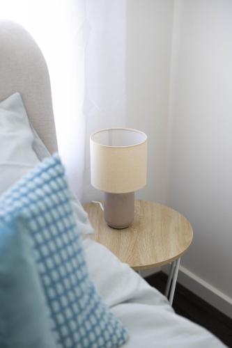 a lamp on a table next to a bed at Lake Illawarra Family Escape in Lake Illawarra