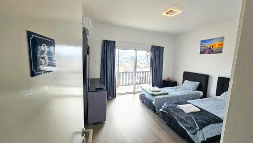 a room with two beds and a window at Downtown Rooms, 200m from Marina Beach in Larnaka