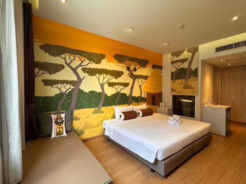a bedroom with a bed with a painting of trees at Beat Hotel Bangkok in Bangkok