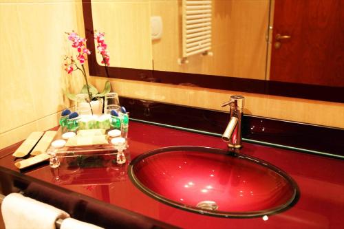 a bathroom with a red sink and a mirror at Augusta Lucilla Palace in Rome