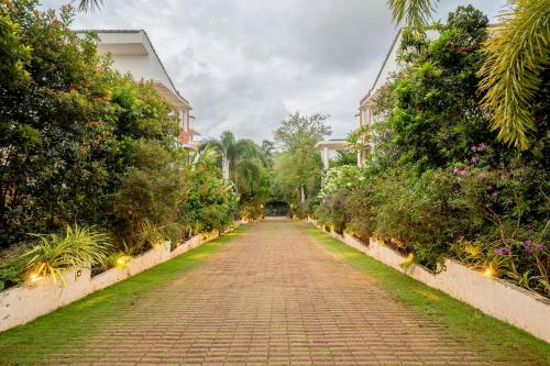 a brick road leading to a house with plants at HideAway 2BHK Duplex Villa, North Goa (STU) in Mapusa