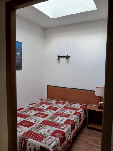 a bedroom with a bed with a red and white blanket at Grand appartement pour famille ou groupe en montagne - SKI- in Saint-François-Longchamp