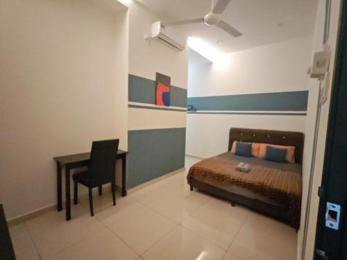 a bedroom with a bed and a table and a desk at The Blue Guest House, WiFi, Free Parking, Aulong in Taiping