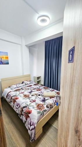 a bedroom with a bed with a floral comforter at Downtown Rooms, 200m from Marina Beach in Larnaka