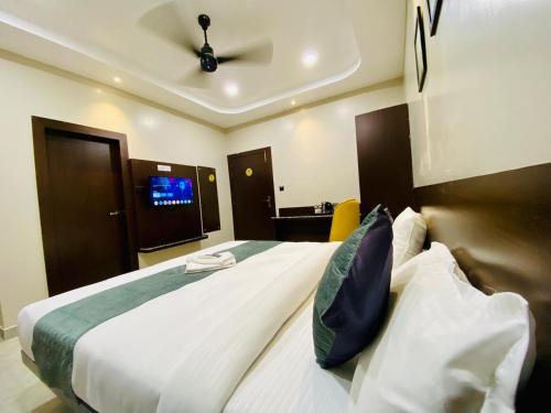 a bedroom with a large white bed with a ceiling at Park Abode Boutique Guest House in Guwahati
