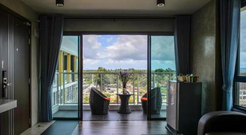 a living room with a large glass door with a balcony at B2 Krabi Premier Hotel in Ao Nang Beach
