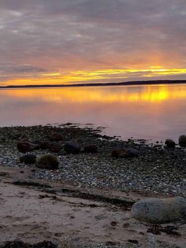 a sunset on the shore of a body of water at Quiet Area, 15 Km To The Beach in Skibby