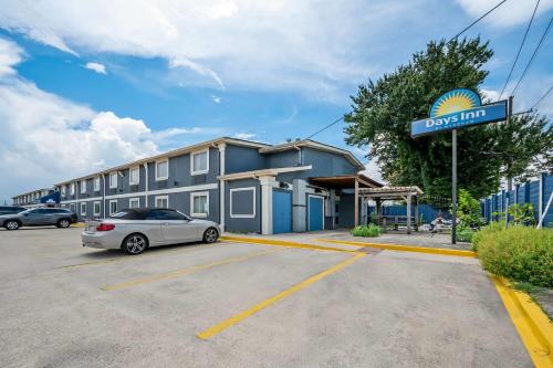 a car parked in a parking lot in front of a hotel at Days Inn by Wyndham New Orleans Pontchartrain in New Orleans