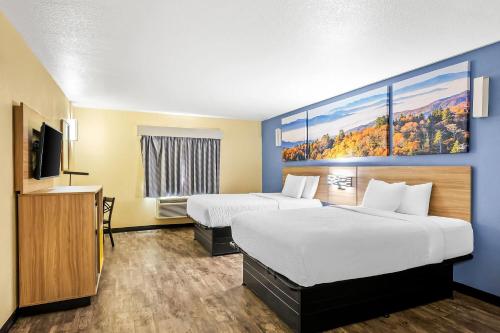 a hotel room with two beds and a flat screen tv at Days Inn by Wyndham New Orleans Pontchartrain in New Orleans