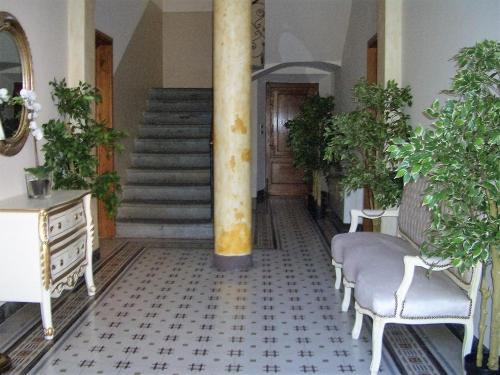 a hallway with a column and chairs and a staircase at Lucca Relais in Lucca