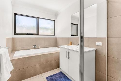 a bathroom with a tub and a sink at Beachside Retreat in Cowes
