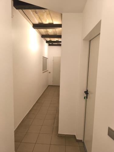 an empty hallway with white walls and a tile floor at Studio3 in Utena