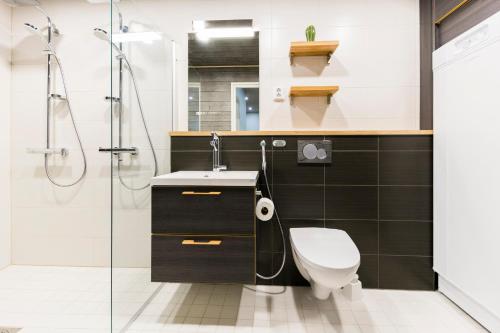 a bathroom with a toilet and a sink and a shower at Levin Sirius Apartments Visit Levi in Levi