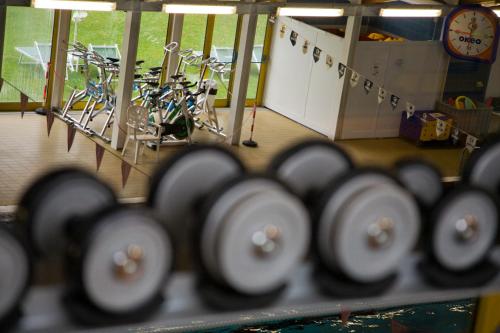 a row of bikes parked in a room with a clock at Hotel Federico II in Iesi