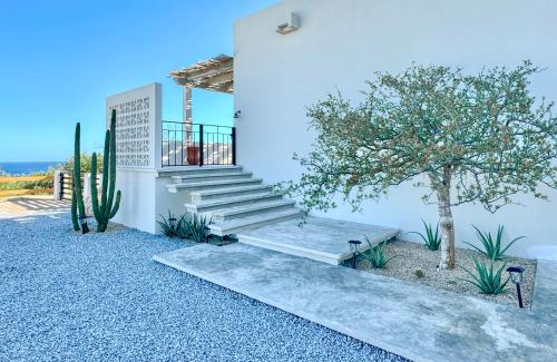 a house with stairs and a tree in front of it at Casa del Mar - Luxury Seaside Villa in Boca de la Vinorama