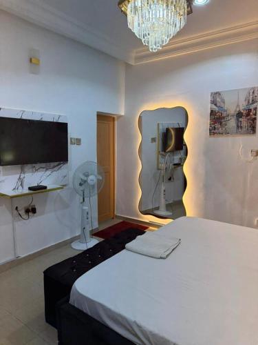 a bedroom with a bed and a tv and a fan at realtor michael in Garki
