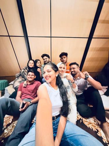 a group of people sitting on beds in a room at Cherry Blossoms Chalet in Kozhikode