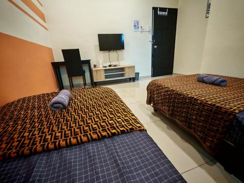 a bedroom with two beds and a tv and a chair at The Blue Guest House, WiFi, Free Parking, Aulong in Taiping