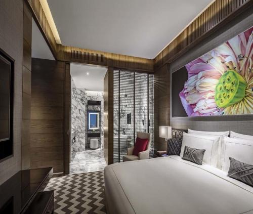 a bedroom with a large bed with a large flower painting on the wall at Hotel Admiral Near Delhi Airport in New Delhi