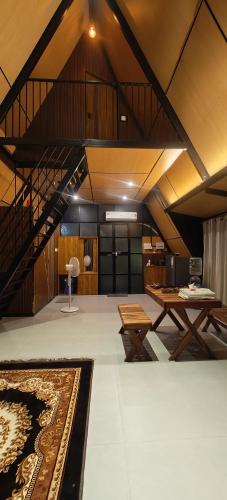 a large room with a staircase and tables and a rug at Cherry Blossoms Chalet in Kozhikode