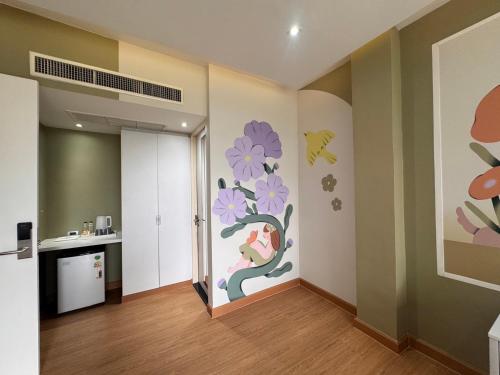 a room with a wall with a mural of flowers at Beat Hotel Bangkok in Bangkok