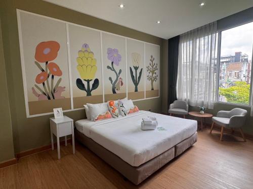 a bedroom with a bed with flowers painted on the wall at Beat Hotel Bangkok in Bangkok