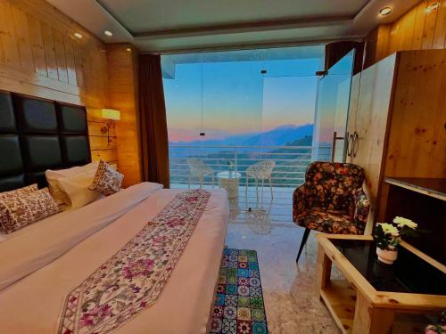 a bedroom with a bed and a balcony with a view at Hotel Classic Crown - #scenic mountain view #open terrace #parking #premium rooms with balcony #guest preferred #best selling hotel in mussoorie in Mussoorie