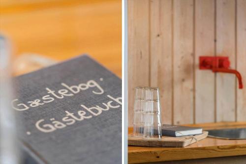 a book and a glass on a wooden table at 218-Harboore-Dalevej-6-a in Harboør