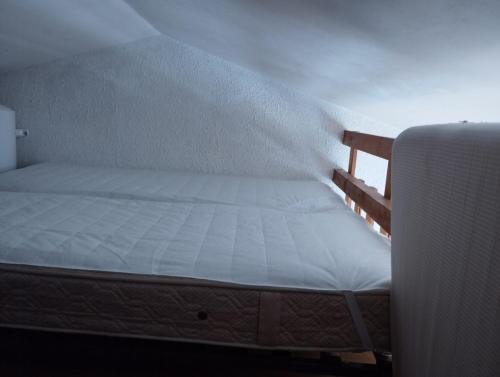 ein Bett in einem Zimmer neben einer Wand in der Unterkunft charmant studio Mezzanine vue mer,près du port in La Londe-les-Maures