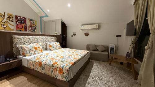 a bedroom with a bed and a couch at Himadvaya- The Himalayan Prism in Almora