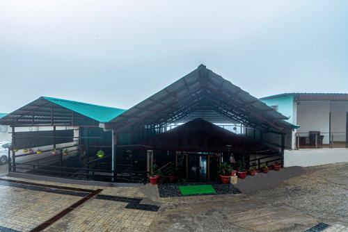 a building with a black roof with potted plants at Treebo Premium Queen Of Hills Near Mall Road in Mussoorie
