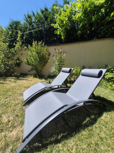 a couple of white lounge chairs sitting in the grass at Chalet avec Jacuzzi, billard, jardin clos, proche Paradiski in Aime La Plagne