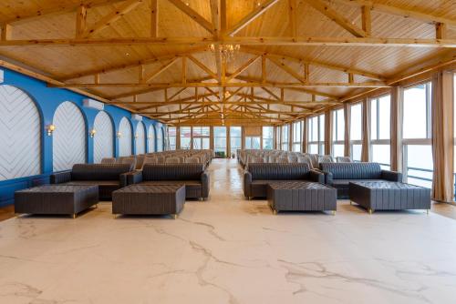 a room with rows of chairs in a building with windows at Treebo Premium Queen Of Hills Near Mall Road in Mussoorie