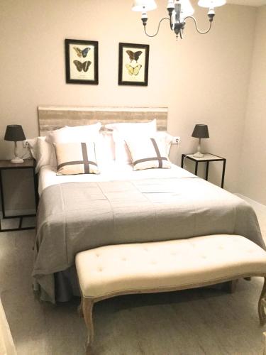 a bedroom with a large bed with a bench at Morendal-Zaaita in Soria