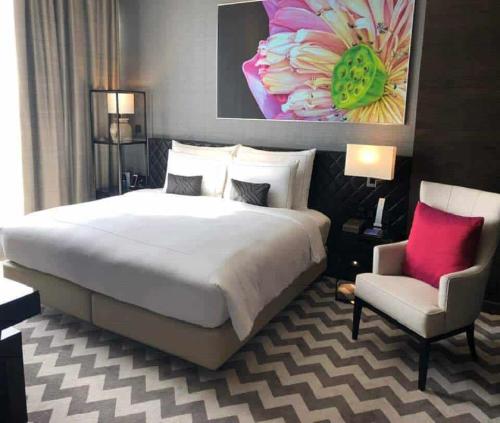 a bedroom with a large bed and a chair at Hotel Admiral Near Delhi Airport in New Delhi