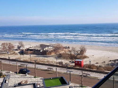 a beach with a red house and the ocean at Alezzi Seaside in Năvodari
