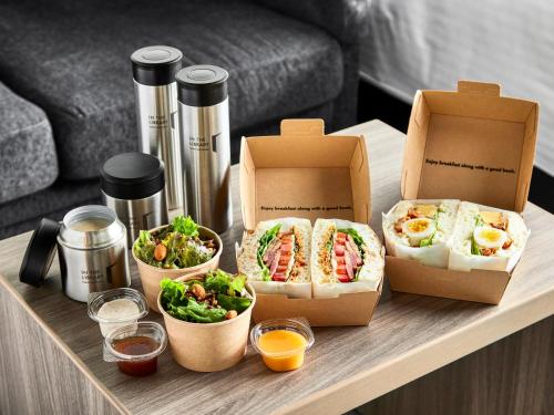 a table with two boxes of sandwiches and salad at IN THE LIBRARY hotel and books TOKOROZAWA - Opening in 15th July 2025 in Tokorozawa