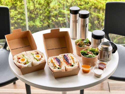 two boxes of sandwiches on a table with food at IN THE LIBRARY hotel and books TOKOROZAWA - Opening in 15th July 2025 in Tokorozawa