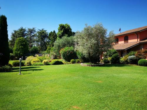a yard with a house and green grass at B&B Villa Argiolas in Modena