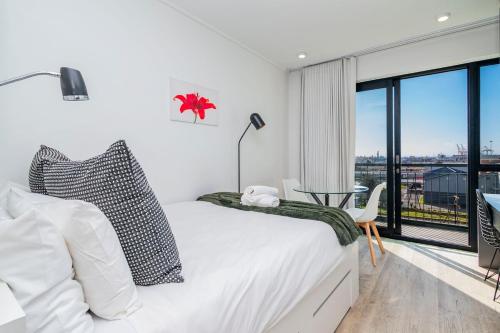 Una habitación blanca con una cama y una ventana en Stylish Studio in One on Albert, en Hout Bay