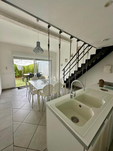 a white kitchen with a sink and a table at Mas de l Aire in Corneilla-del-Vercol