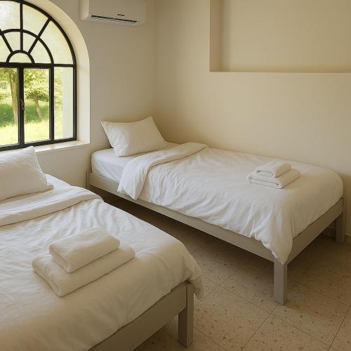 two beds sitting next to each other in a room at הבית בלב העתיקה in Safed