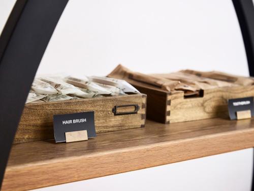 two boxes on a wooden shelf with signs on it at IN THE LIBRARY hotel and books TOKOROZAWA - Opening in 15th July 2025 in Tokorozawa
