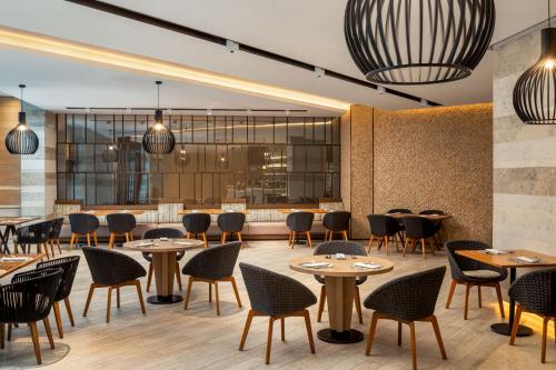 a restaurant with tables and chairs and a bar at Saadiyat Rotana Resort and Villas in Abu Dhabi