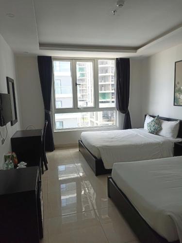 a hotel room with two beds and a window at Orchids Ocean Hotel in Da Nang